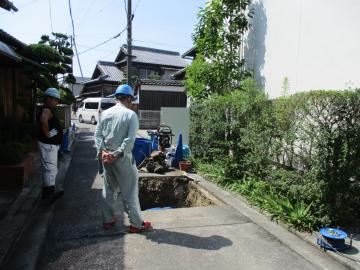 水道工事現場を監督する職員の写真